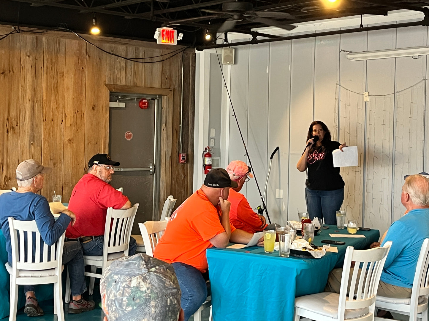 Cathy Sanders speaking, wearing a black and pink Fishin' Girl t-shirt
